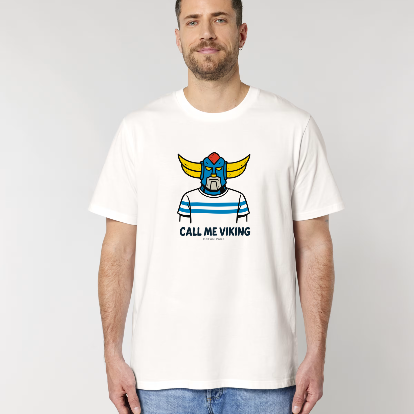Homme de dos portant un t-shirt blanc avec une grande illustration carrée bleue et jaune représentant un surfeur sur une vague, le texte "CULTURE SURF" en lettres bombées et le logo "ocean park".