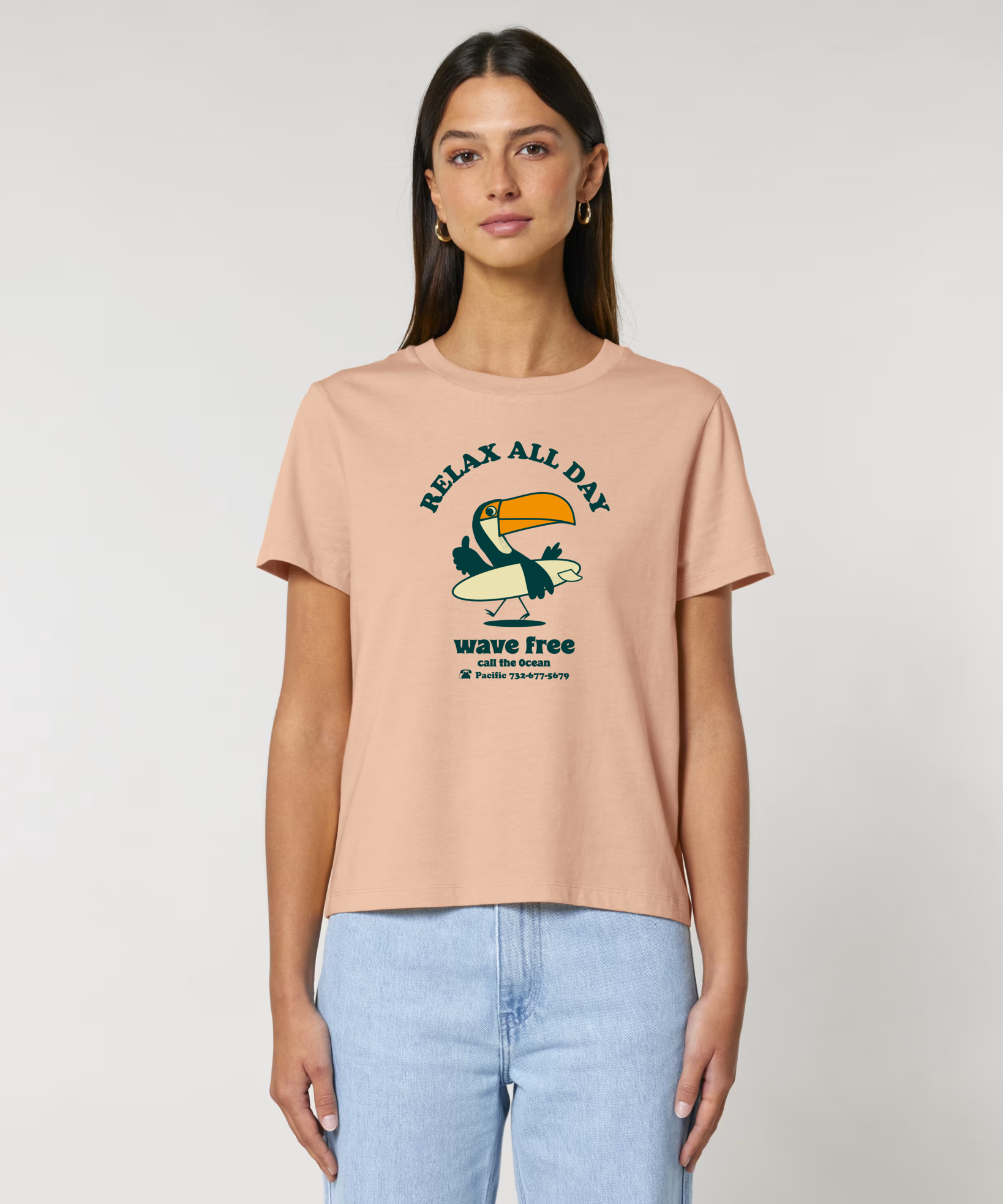 T-shirt femme Ocean Park coloris Fraîche Pêche, imprimé humoristique toucan surfeur, coupe Muser ajustée en coton.