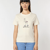 Femme de face portant un t-shirt blanc cassé avec une illustration centrale d'un flamant rose chaussé de patins à roulettes rétro, surmontant l'inscription "Rolling Flamingo".