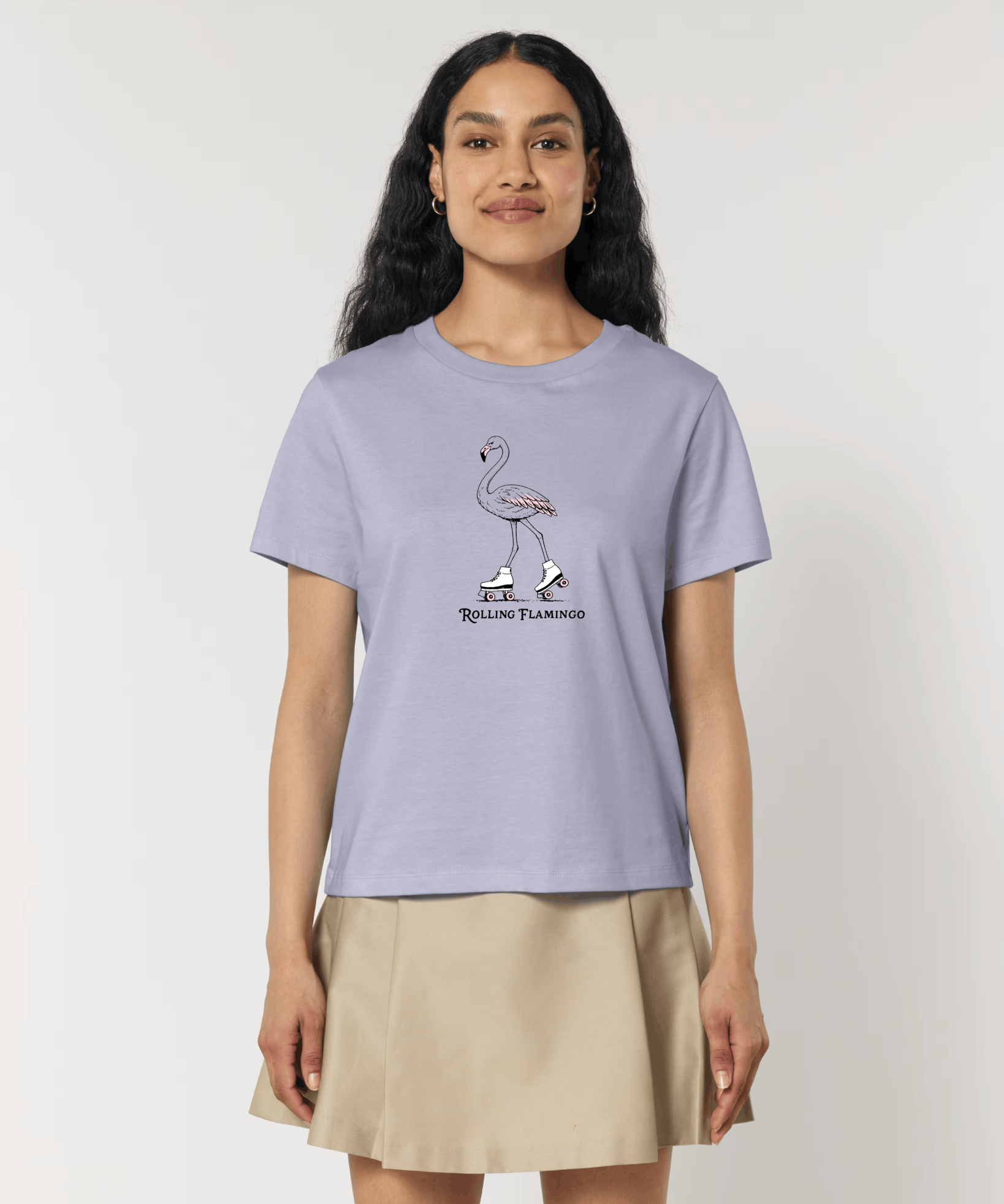 Femme de face portant un t-shirt lilas avec une illustration centrale d'un flamant rose portant des patins à roulettes blancs, accompagnée de l'inscription "Rolling Flamingo".