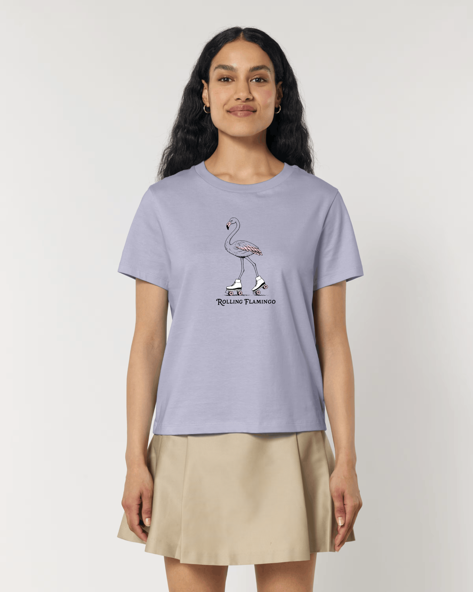 Femme de face portant un t-shirt lilas avec une illustration centrale d'un flamant rose portant des patins à roulettes blancs, accompagnée de l'inscription "Rolling Flamingo".