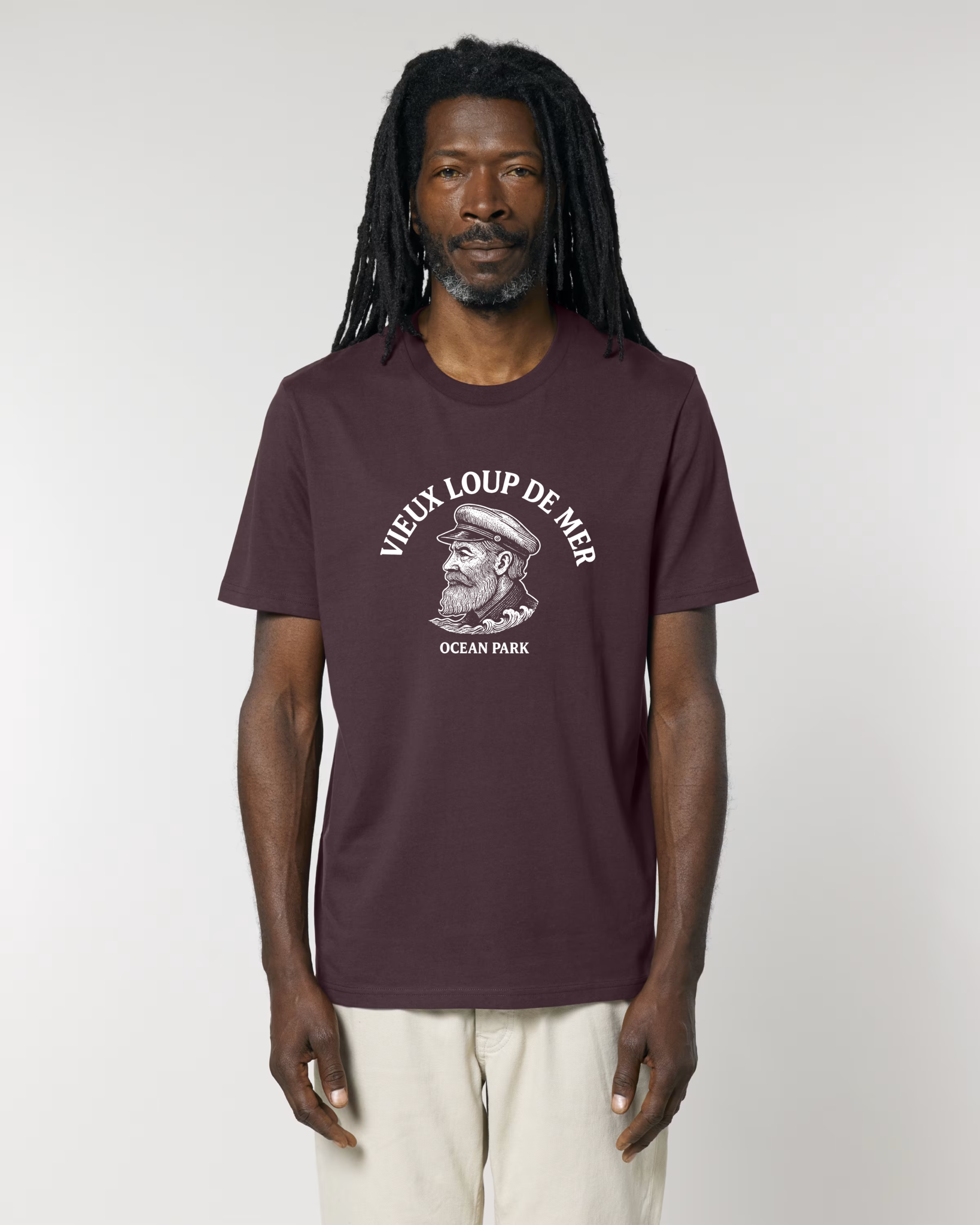 Homme portant un t-shirt de couleur bordeaux foncé (red brown) avec une illustration blanche centrale d'un vieux capitaine barbu avec une casquette de marin, surmontée du texte en arc de cercle "VIEUX LOUP DE MER".